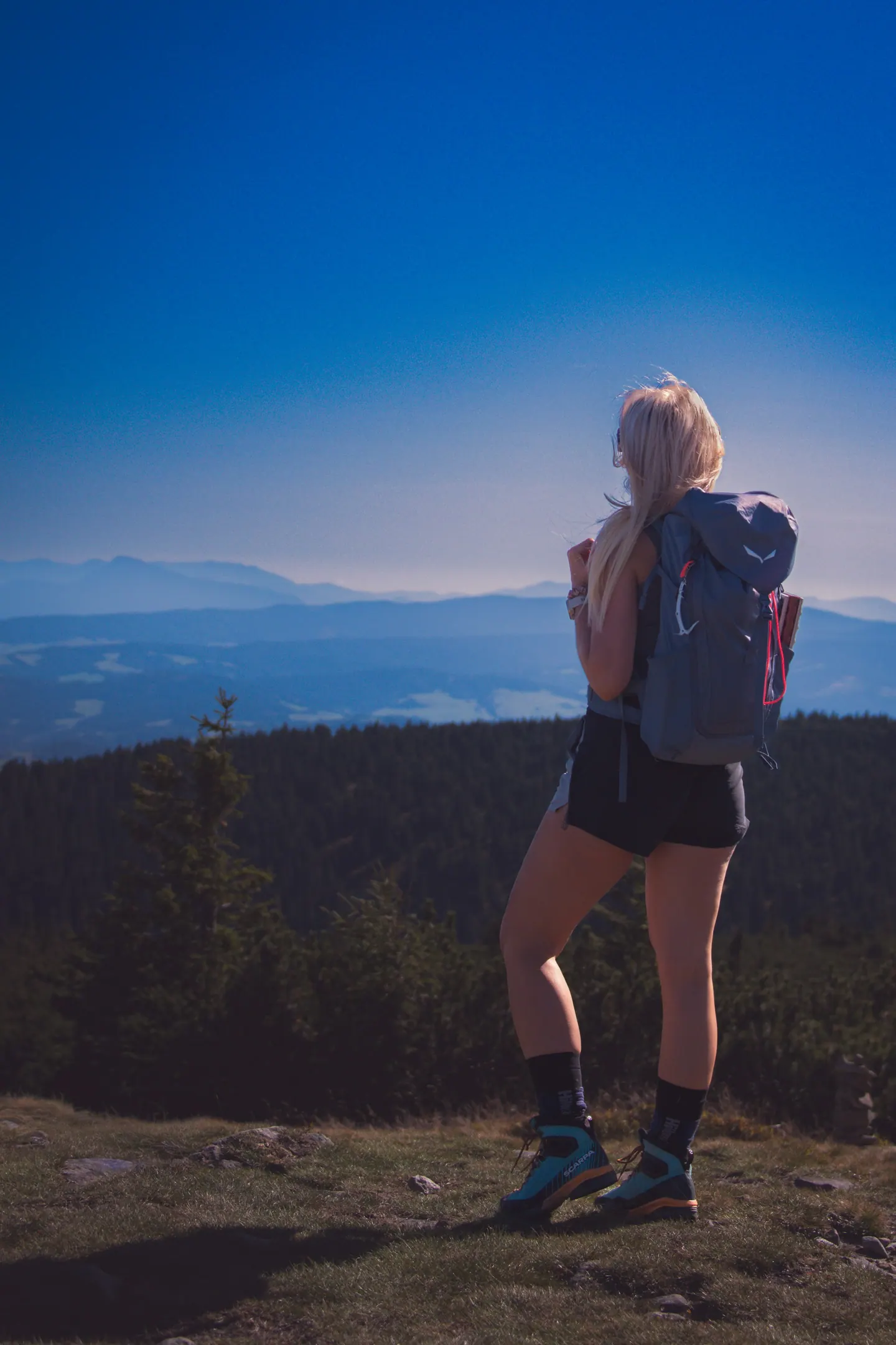 Woman with a backpack overlooking a mountain landscape